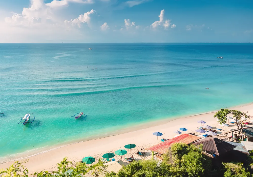 Turquoise water and outrigger boats on a Bali beach